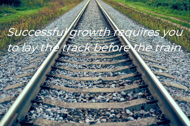Railway track line going into distance, railroad train track with crushed stone, two parallel rails.