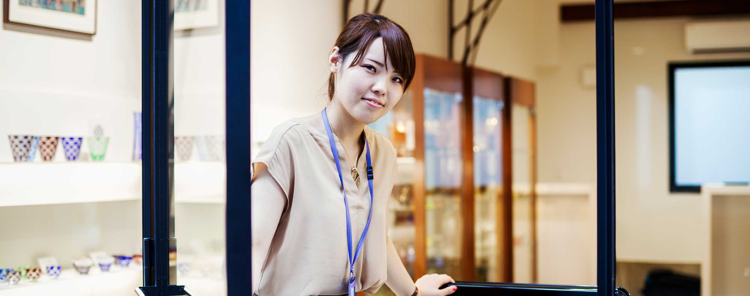 A saleswoman standing at a counter in a shop.